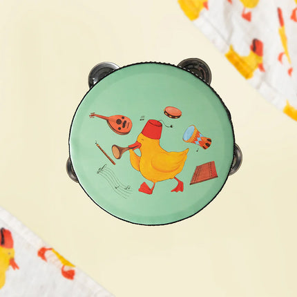 A tambourine for kids in mint color with a yellow duckling print at the center of other musical instruments around it.