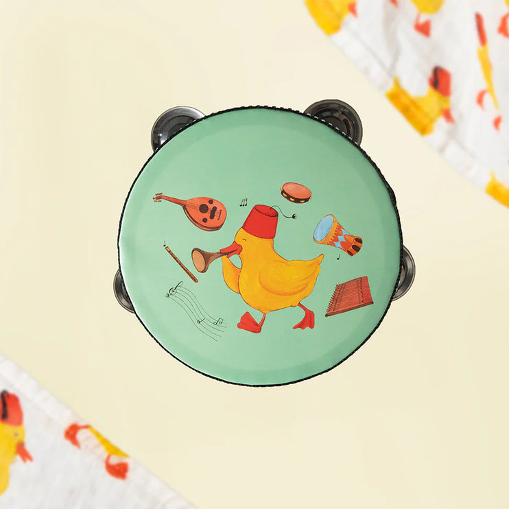 A tambourine for kids in mint color with a yellow duckling print at the center of other musical instruments around it.